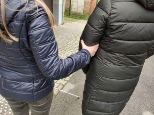 Fotografija slepe osebe, ki se drži spremljevalca