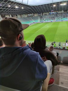 slepi udeleženec spremlja nogometno tekmo preko slušalke