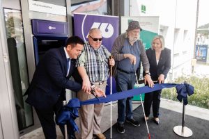 Otvoritev bankomata prilagojenega za slepe. Predsednik ZDSSS Matej Žnuderl in član uprave NLB Antonio Argir sta prerezala otvoritveni trak.