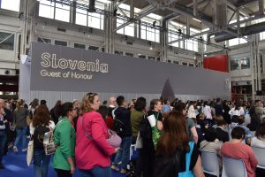 Obiskovalci na otvoritvi sejma. v odzadju je pano z napisom Slovenia guest of honor