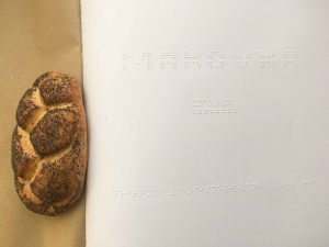 Na sliki je priročnik za poučevanje brajice in makova pletenka