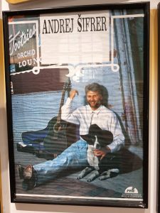 Na sliki je ovitek plošče Hiti počasi. Andrej sedi na tleh pred lokalom, poleg njega je kitara, z levo roko objema črno-belegha psa, ki ima na glavi klobuk. Plošča je bila posneta v Ameriki.