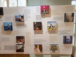 Na sliki je vitrina, v kateri so fotografije Andreja Šifrerja in natisnjeni odlomki besedil njegovih pesmi.